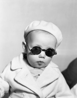 Portrait of baby wearing beret and sunglasses clipart