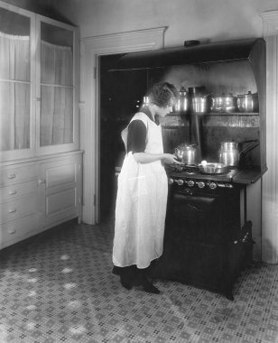 Mutfakta yemek pişiren kadın.