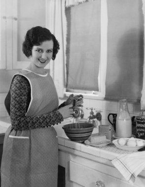 Woman cooking in kitchen clipart