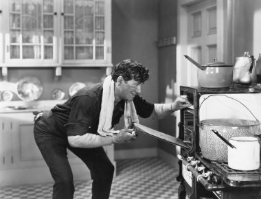 Man looking into oven clipart