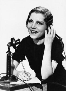 Smiling woman using telephone clipart