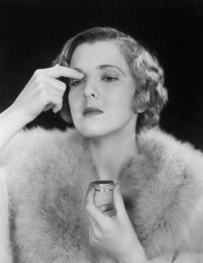 Portrait of woman applying makeup clipart