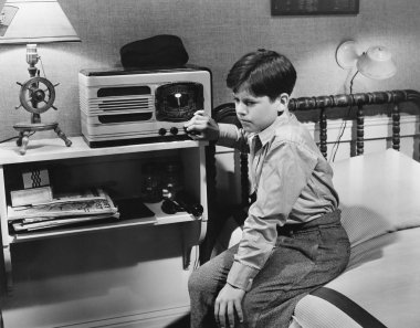 Boy listening to radio in bedroom clipart