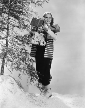 Woman outside in snow with Christmas presents clipart