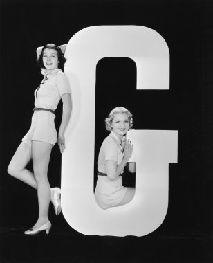 Women posing with huge letter G clipart