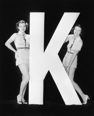 Women posing with huge letter K clipart