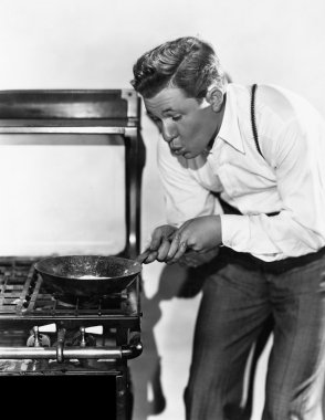 Portrait of man cooking on stove clipart