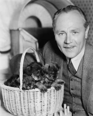 Man with puppies in a basket clipart