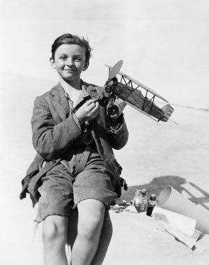 Portrait of a boy holding a model airplane and smiling clipart