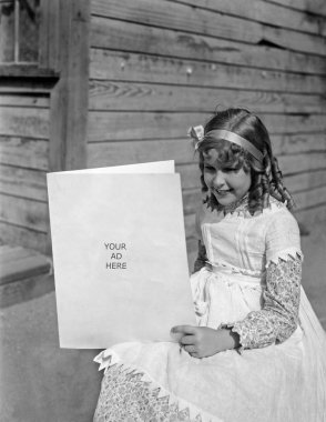 Girl in a white dress sitting and holding a card clipart