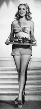 minyatür bir trenin tutan genç bir kadın portresi