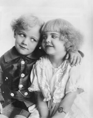 Portrait of a boy and girl with arm around her clipart