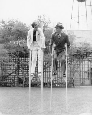 Couple walking on stilts clipart