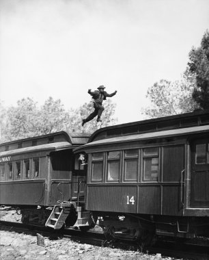 Man leaping across the roof of railroad cars clipart