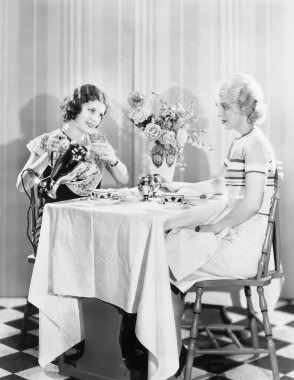 Two women having tea together clipart