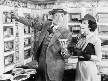 Man serving a dish to a woman in a Automat clipart