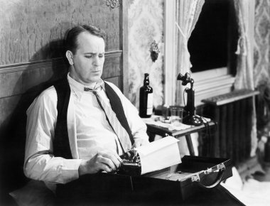 Journalist sitting on his bed with a typewriter, typing clipart