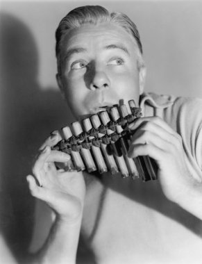 Man playing a pan flute clipart