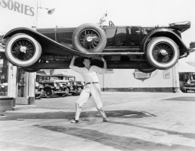 Strong man lifting a car over his head clipart