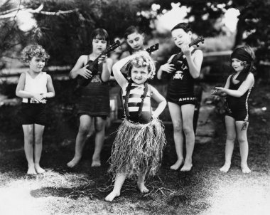 Group of children performing with instruments and one girl dancing the hula clipart