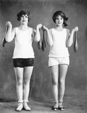 Two women exercising with juggling pins clipart