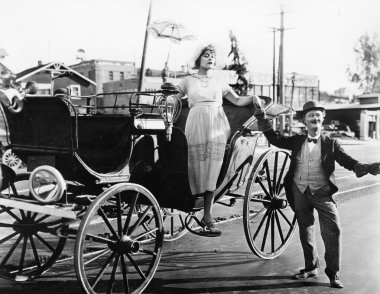 Man helping a woman get out of a wagon clipart