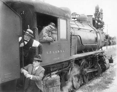 Three men waiting at a steam locomotive clipart