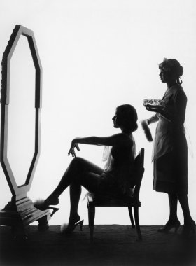 Two women in front of a large mirror clipart