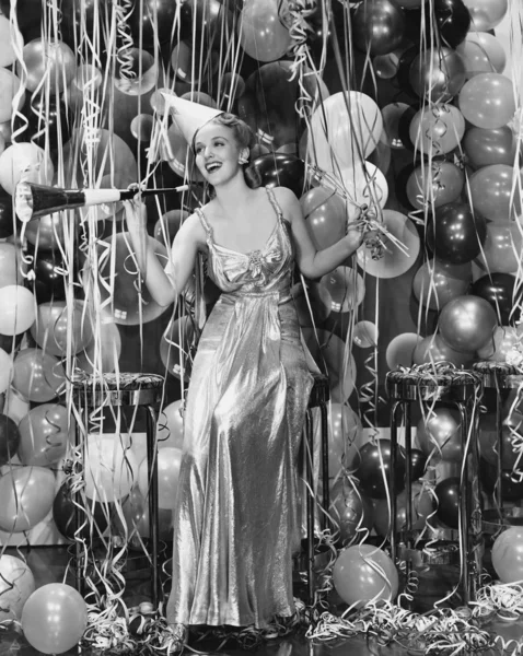 Frau feiert mit Raum voller Luftballons — Stockfoto