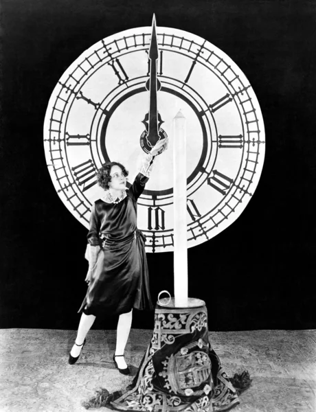 Mujer con vela y reloj en Nochevieja —  Fotos de Stock