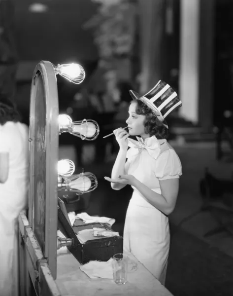 Mulher em traje aplicando maquiagem — Fotografia de Stock