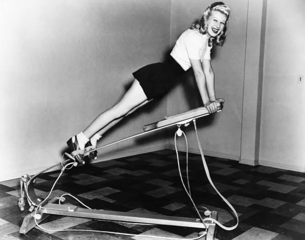 Mulher usando equipamento de exercício — Fotografia de Stock