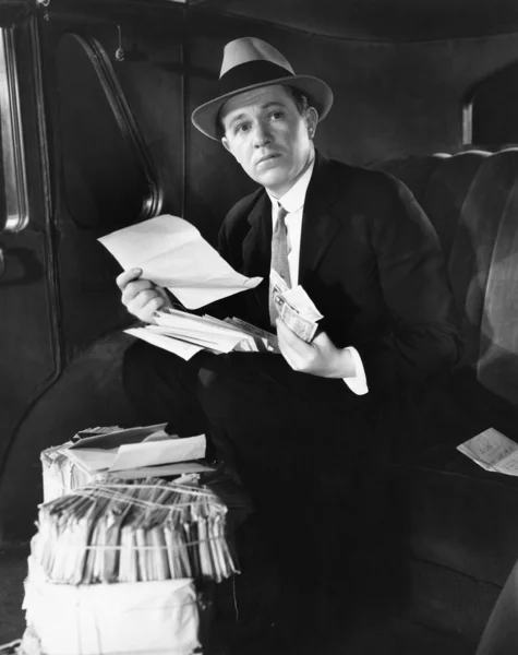 Man in auto met bundels van mail — Stockfoto
