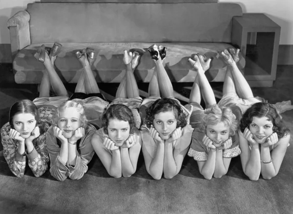Retrato de mulheres jovens em fila no chão — Fotografia de Stock