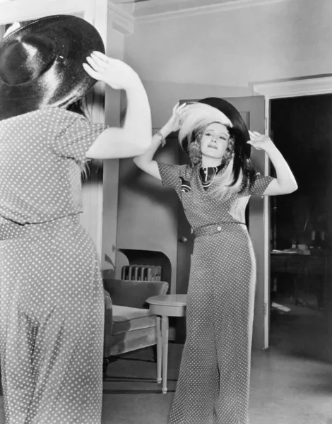 Kvinnan försöker på hatt — Stockfoto