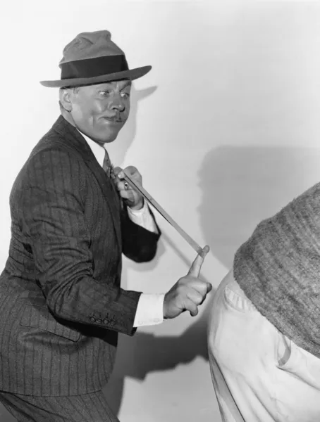 Hombre rompiendo el extremo trasero con banda de goma — Foto de Stock