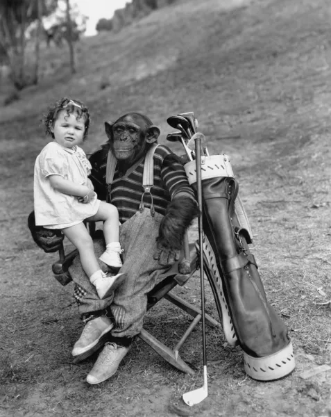 A golf klubok és kisgyermek lány majom — Stock Fotó