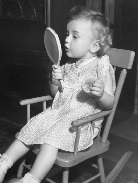 Malá holčička hledá v zrcadle — Stock fotografie