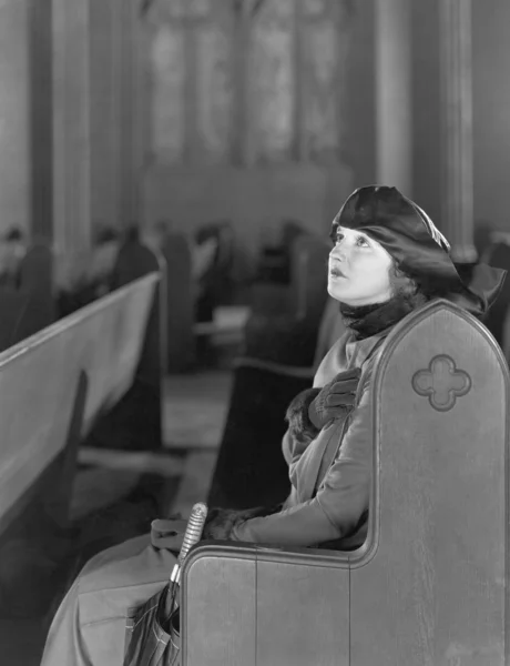 Женщина, молящаяся в церкви — стоковое фото