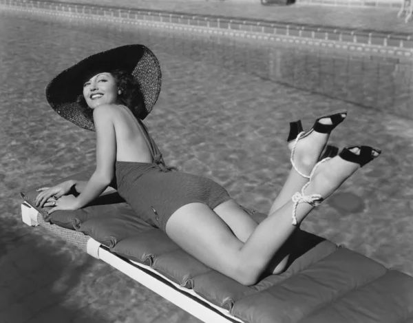 Žena opalování u bazénu — Stock fotografie