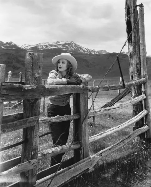 stock image Woman leaning on wooden fence on ranch