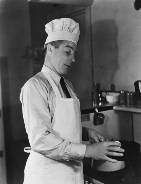 Uomo in cuoco cappello e grembiule cucina — Foto Stock
