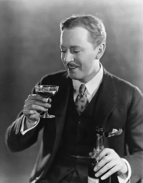 Homem sorridente com bebida e garrafa — Fotografia de Stock