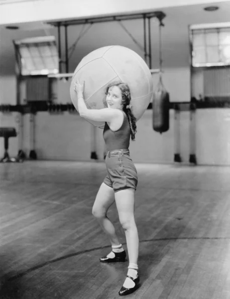 Frau in Turnhalle mit riesigem Ball — Stockfoto