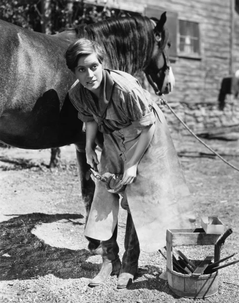 Kvinna skoning häst — Stockfoto