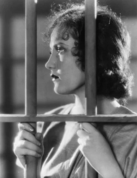 Closeup of woman behind bars — Stock Photo, Image