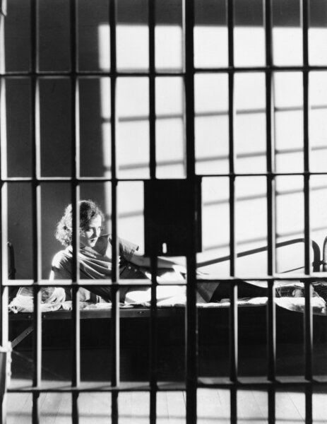 Woman through bars of jail cell