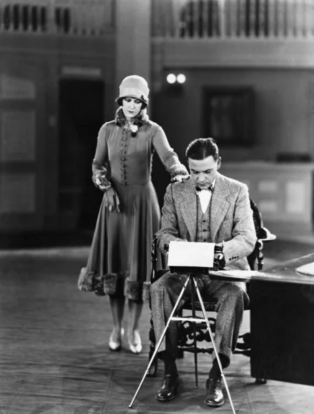 Женщина прерывает мужчину на пишущей машинке — стоковое фото