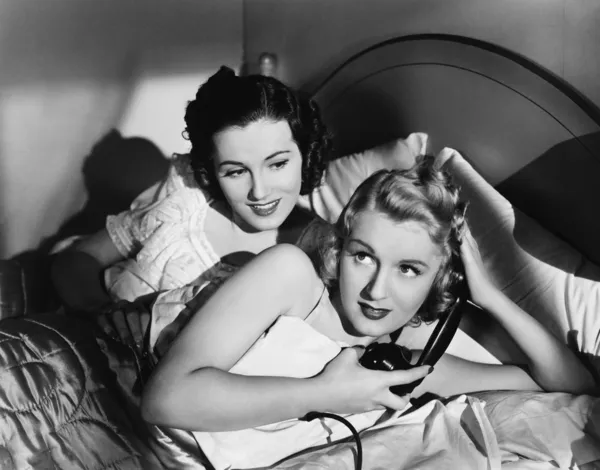 Dvě ženy v posteli s telefonem — Stock fotografie