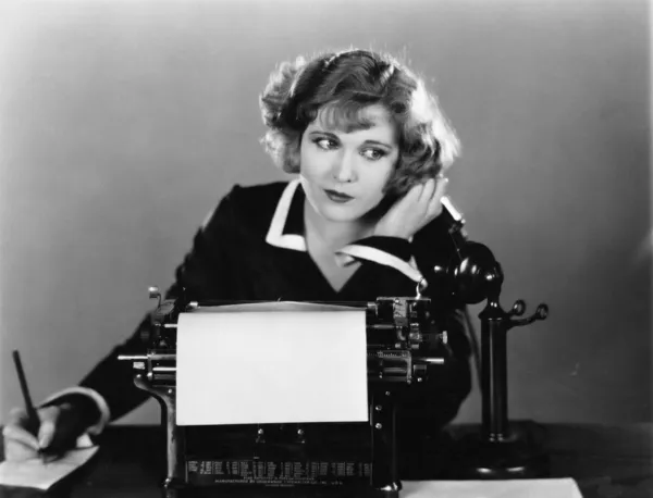 Woman at typewriter on telephone — Stock Photo, Image